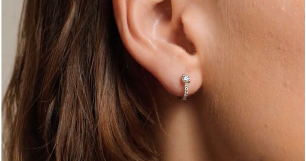 Brilliant Earth's 14K Yellow Gold Taylor Lab Diamond Huggie Earrings from Right Ear.